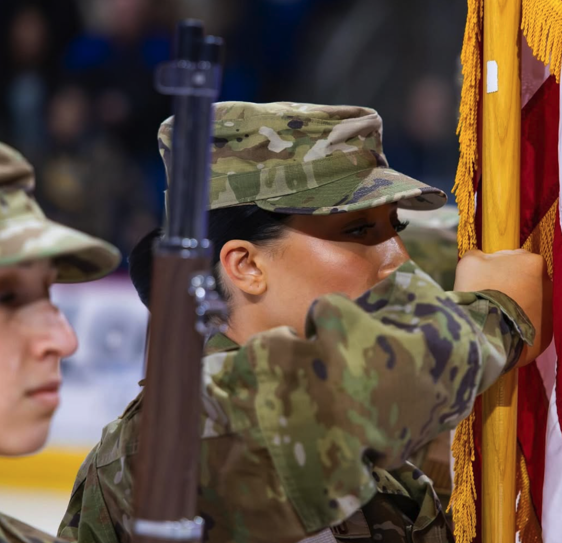 An Air Force Cadet performs in a color guard at a hockey game.