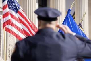 A police officer salutes the American flag