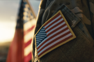 Service member facing an American flag in the background