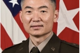 A portrait of BG Siegl in front of the American flag.