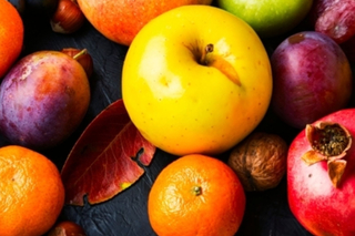Fruits and leaves on a black tabletop.